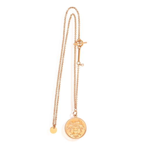 128 - A DIAMOND AND GOLD 'EX-LIBRIS' PENDANT NECKLACE, BY HERMÈS  Composed of a circular plaque with logo ... 