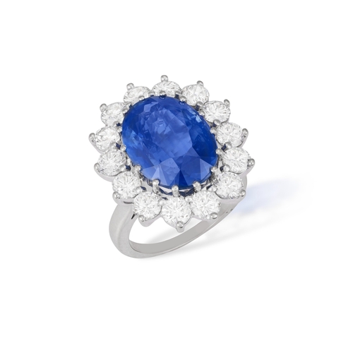 139 - A SAPPHIRE AND DIAMOND CLUSTER RING  The oval-shaped sapphire weighing approximately 9.00cts, within... 