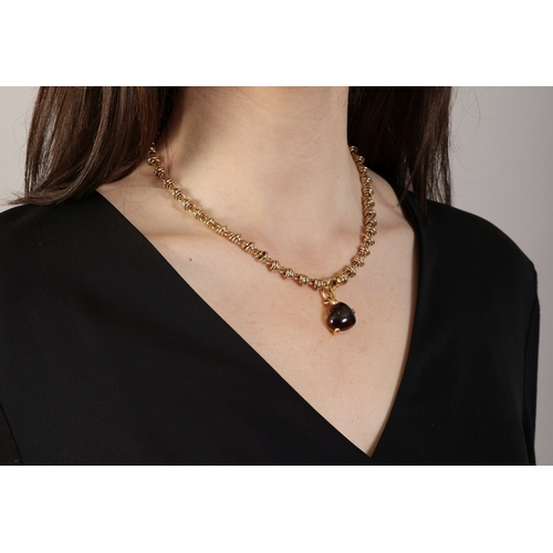 160 - A GOLD NECKLACE WITH GARNET PENDANT, BY POMELLATO  The detachable pendant set with a heart-shaped ga... 