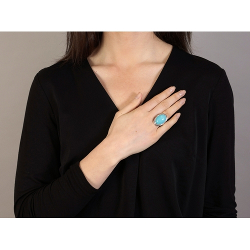 166 - A TURQUOISE, ENAMEL AND DIAMOND DRESS RING  The oval-shaped turquoise cabochon within a frame pavé-s... 