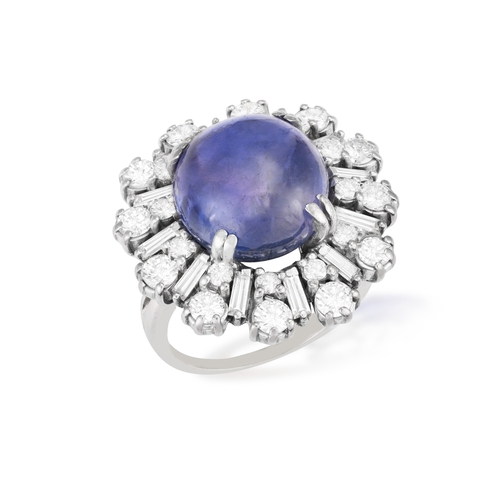 212 - A SAPPHIRE AND DIAMOND CLUSTER RING, CIRCA 1960  The oval-shaped sapphire cabochon weighing approxim... 