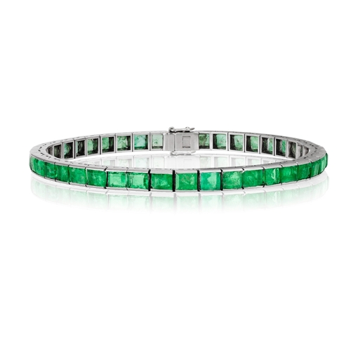 235 - AN EMERALD LINE BRACELET  Composed of a continuous line of rectangular-cut emeralds, mounted in 18K ... 