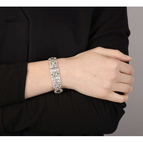 29 - A DIAMOND BRACELET  Composed of openwork motifs of geometric and foliate design, the central one cen... 