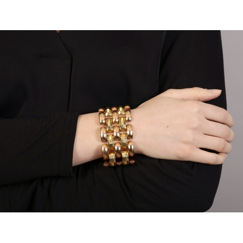 35 - A GOLD RETRO COCKTAIL BRACELET, CIRCA 1940  Of bi-coloured design, the large articulated bracelet co... 