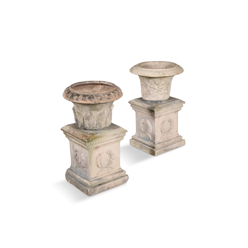 4 - A PAIR OF TAN-TERRACOTTA GARDEN PLINTHS,   each fitted with associated urns. 70cm high