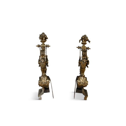 41 - A PAIR OF BRASS FIRE DOGS,   in the form of winged griffins, perched on pierced brackets. 53cm high