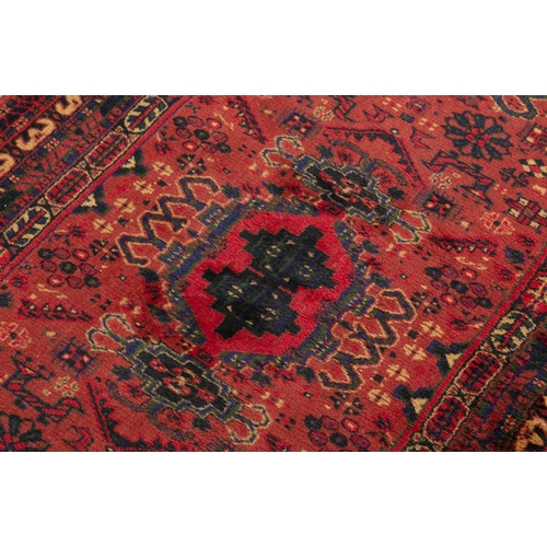 51 - A TURKISH WOOL RUNNER WITH RED GROUND, 300CM X 95CM  the central field woven with three geometric me... 