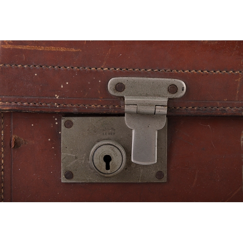 20 - A LEATHER TRAVEL SUITCASE, EARLY 20TH CENTURY,  with remnants of 'Tramore, Waterford' travel label. ... 