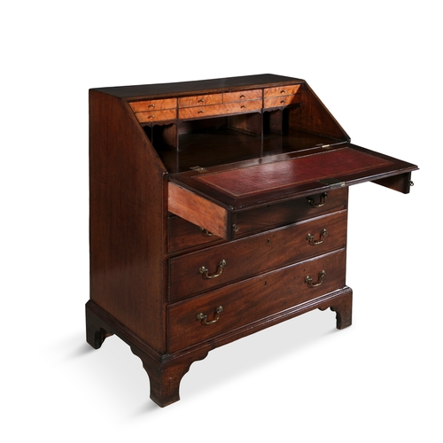 330 - A GEORGE III MAHOGANY SLOPE FRONT BUREAU   the crossbanded sloped front panel enclosing a tooled lea... 