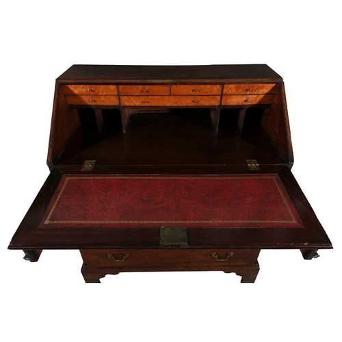 330 - A GEORGE III MAHOGANY SLOPE FRONT BUREAU   the crossbanded sloped front panel enclosing a tooled lea... 