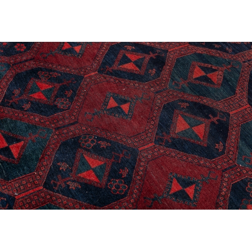 37 - AN AFGHAN RED GROUND WOOL RUG. 235CM LONG, 147CM WIDE   the central field woven with a series of int... 