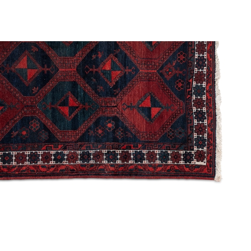 37 - AN AFGHAN RED GROUND WOOL RUG. 235CM LONG, 147CM WIDE   the central field woven with a series of int... 