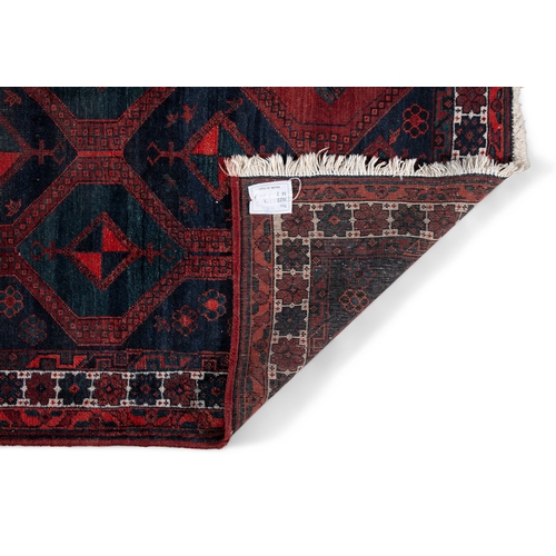 37 - AN AFGHAN RED GROUND WOOL RUG. 235CM LONG, 147CM WIDE   the central field woven with a series of int... 