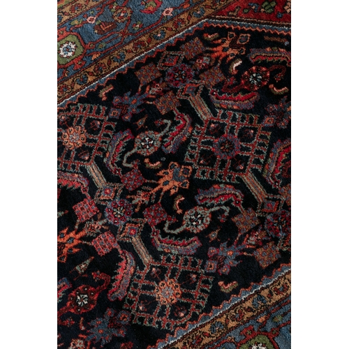 38 - A BLUE AND RED GROUND WOOL RUG 210CM LONG, 130CM WIDE   with central lozenge against a navy ground d... 