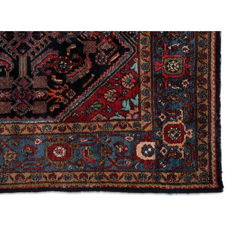 38 - A BLUE AND RED GROUND WOOL RUG 210CM LONG, 130CM WIDE   with central lozenge against a navy ground d... 