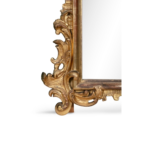 399 - A LARGE VICTORIAN GILTWOOD MIRROR,  of shaped rectangular form, the arched bevelled glass plate with... 