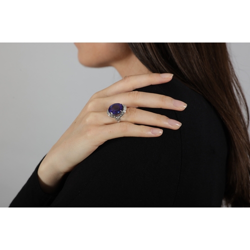 111 - A TANZANITE AND DIAMOND DRESS RING  The oval-shaped tanzanite weighing approximately 14.50cts within... 