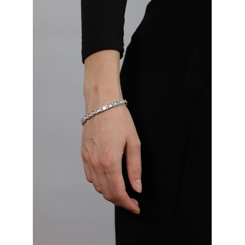 125 - A DIAMOND LINE BRACELET  Composed of a series of channel-set baguette-cut diamonds, interspersed wit... 