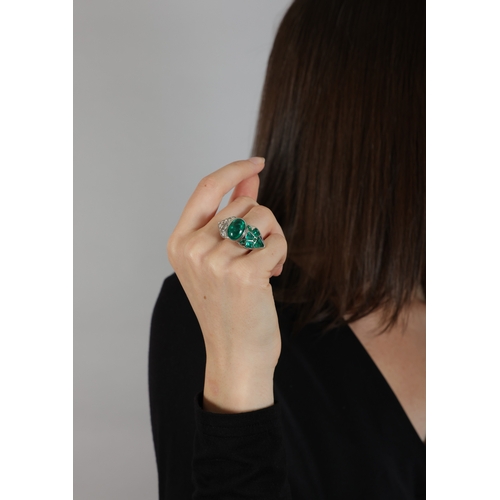 150 - AN EMERALD AND DIAMOND DRESS RING  The central oval-shaped emerald cabochon weighing approximately 5... 