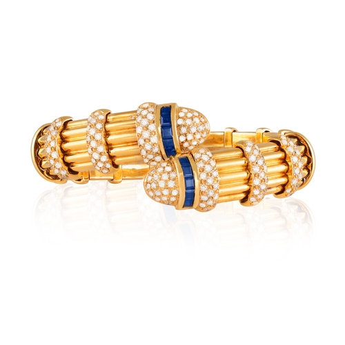 153 - A SAPPHIRE AND DIAMOND BANGLE  Of spring reeded design, with opposing terminals highlighted with bri... 