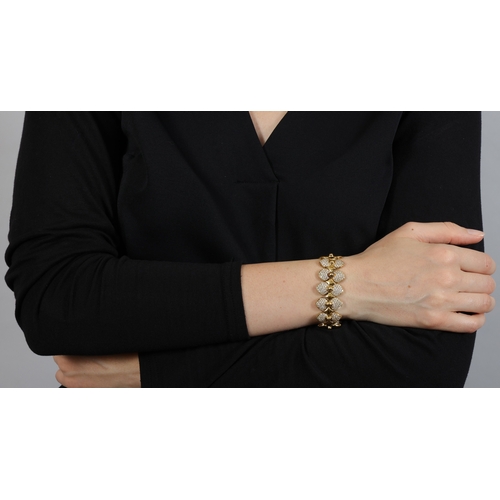 157 - A DIAMOND BRACELET  The highly articulated bracelet with polished links and beaded detailing, centri... 