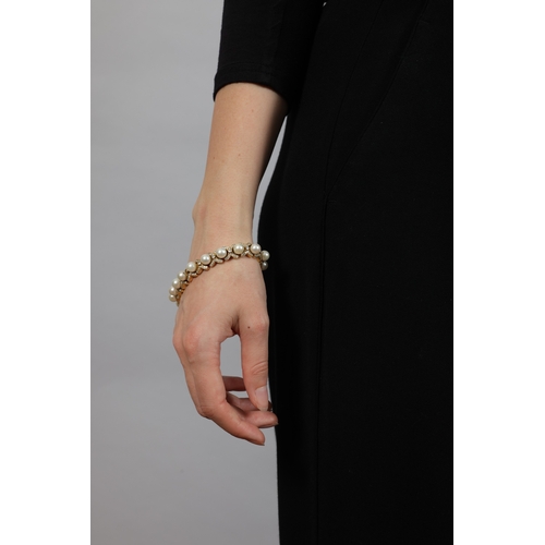 171 - A CULTURED PEARL AND DIAMOND BRACELET  The articulated bracelet set with a line of cultured pearl be... 