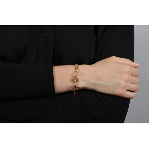 2 - FRED PARIS: A GOLD BRACELET  The chain composed of openwork oval and heart-shaped polished gold link... 