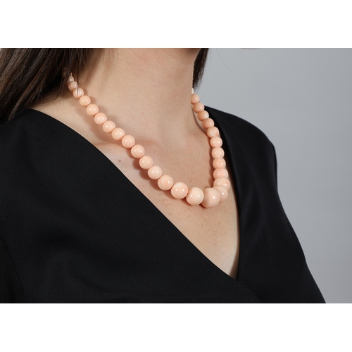 206 - A CORAL BEAD NECKLACE  Composed of a single graduated row of coral corallium secundum beads measurin... 