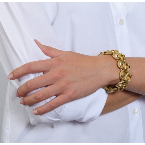 43 - A GOLD BRACELET, CIRCA 1955  Of openwork swirling design, the textured fancy-links with reeded conne... 