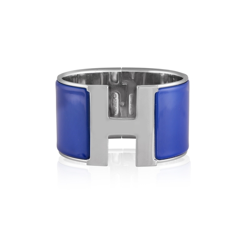 117 - HERMÈS: A 'CLIC CLAC H' BRACELET  The bangle with applied blue enamel, centring an H clasp, signed H... 