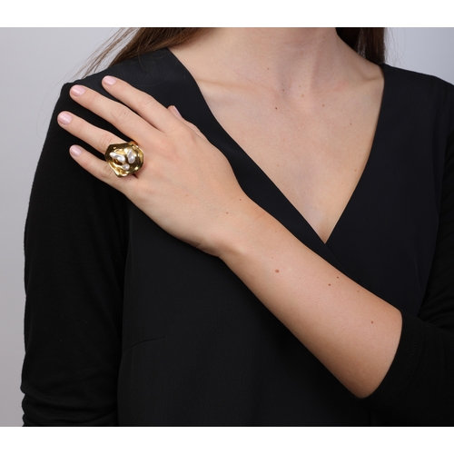 64 - ORNA: A 9K GOLD, FRESHWATER CULTURE PEARL AND MOONSTONE RING  Of polished abstract design, the front... 