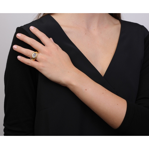64 - ORNA: A 9K GOLD, FRESHWATER CULTURE PEARL AND MOONSTONE RING  Of polished abstract design, the front... 