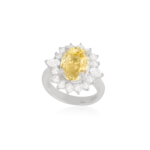 74 - A YELLOW SAPPHIRE AND DIAMOND DRESS RING  Of cluster-design, centring an oval-shaped yellow sapphire... 