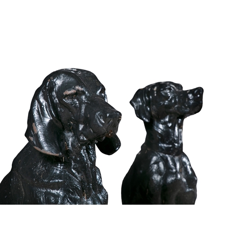 316 - A PAIR OF BLACK PAINTED CAST IRON HOUNDS,   both seated, one with game at its feet, the other with a... 