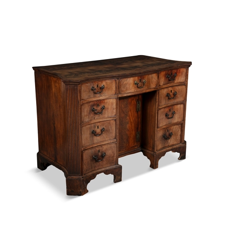 320 - A GEORGE III MAHOGANY SERPENTINE KNEEHOLE DESK C.1760,   the shaped quarter veneer top above an arra... 