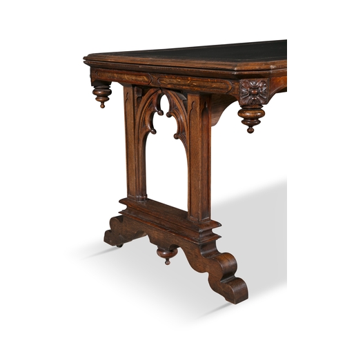 325 - A GOTHIC REVIVAL WALNUT LIBRARY TABLE 19TH CENTURY,   of shaped rectangular form, with canted corner... 