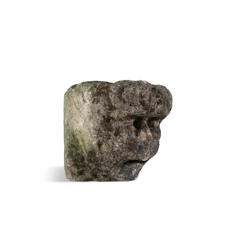 341 - A CELTIC LIMESTONE HEAD  carved in relief with furrowed brow and sunken eyes, deep open mouth, flat ... 