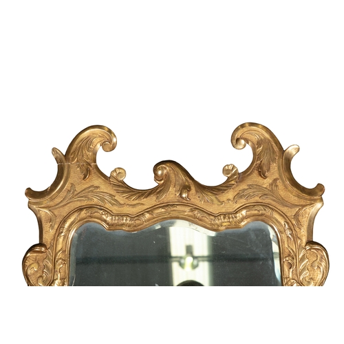 349 - A GEORGE II FLAT CARVED GILTWOOD MIRROR,   the shaped bevelled glass plate contained within a leaf c... 