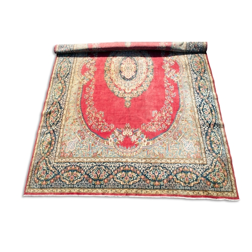 442 - A LARGE PERSIAN RED GROUND RUG, 510CM LONG, 345CM WIDE  the central reserve woven with oval medallio... 