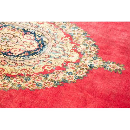 442 - A LARGE PERSIAN RED GROUND RUG, 510CM LONG, 345CM WIDE  the central reserve woven with oval medallio... 