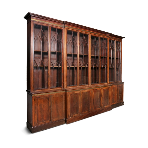 481 - A GEORGE IV MAHOGANY BREAKFRONT BOOKCASE,   with moulded cornice and a brass Greek key banded frieze... 