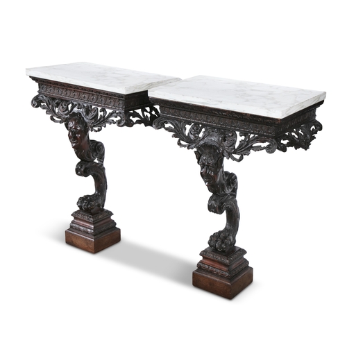 482 - A PAIR OF IRISH GEORGE II STYLE CARVED MAHOGANY VEINED WHITE MARBLE TOP CONSOLE TABLES,  each fitted... 