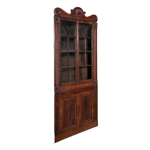 526 - AN IRISH WILLIAM IV MAHOGANY CORNER CABINET, PROBABLY CORK,  the scrollwork cornice carved with cent... 