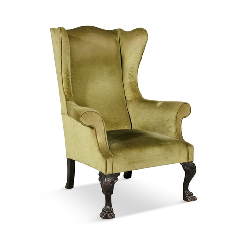 546 - A GEORGIAN UPHOLSTERED MAHOGANY FRAMED WINGBACK ARMCHAIR,   covered in olive green velour, on acanth... 