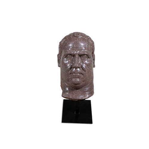 570 - A CARVED PORPHRY STONE HEAD, AFTER THE ANTIQUE,  depicting a Roman Emperor, on later metal stand. 46... 