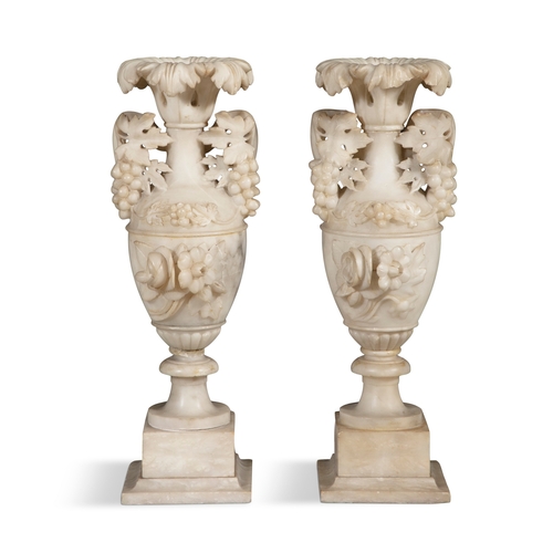 571 - A PAIR OF ALABASTER URNS,  of amphora form, each with outturned carved leaf rims, with naturalistic ... 