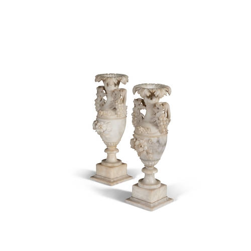 571 - A PAIR OF ALABASTER URNS,  of amphora form, each with outturned carved leaf rims, with naturalistic ... 