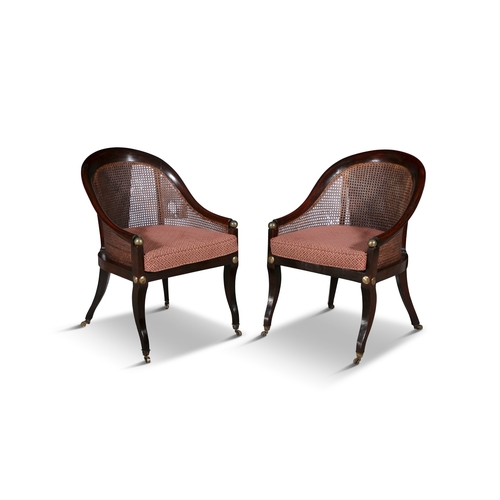 701A - A PAIR OF REGENCY STYLE MAHOGANY TUB BACK LIBRARY CHAIRS 19TH CENTURY  with cane backs and seat, bra... 