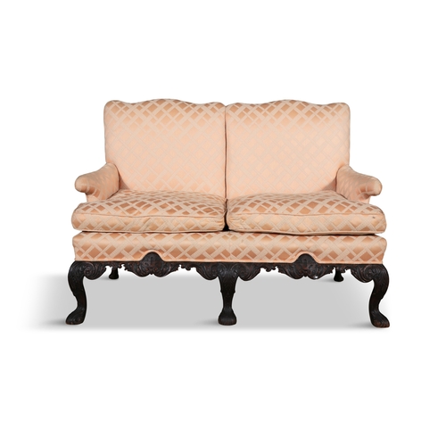 121 - AN IRISH CARVED MAHOGANY FRAMED TWO-SEATER SETTEE 19TH CENTURY,  with two loose cushions, the back s... 