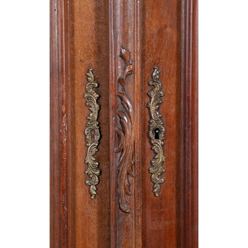 132 - A FRENCH CARVED WALNUT ARMOIRE LATE 18TH/EARLY 19TH CENTURY,  surmounted with a foliate carved arche... 